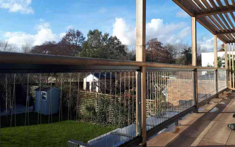 Powder coated diagonal wire balustrade with oak rail