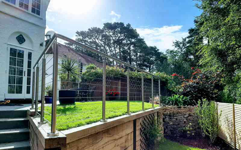 Horizontal wire balustrade on raised garden terrace